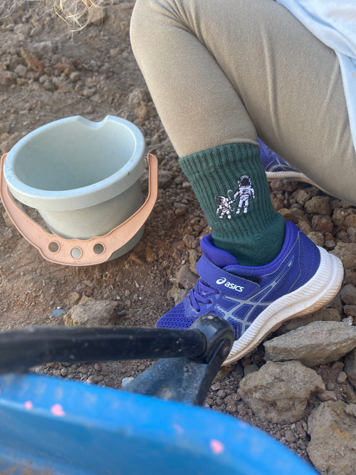 Close-up of kids Small Steps Co. green astronaut sock with purple sneakers